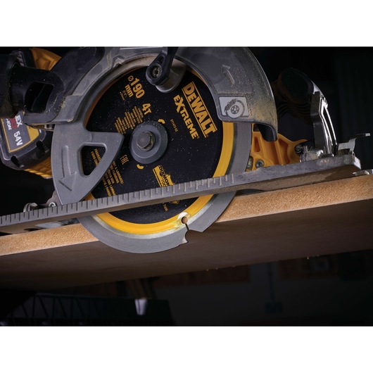 DEWALT DT1472 circular saw cutting wood, close-up of blade and guide rail during operation.