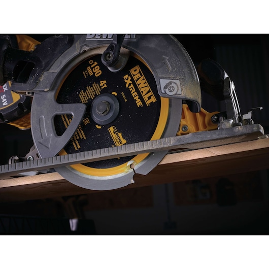 Close-up of a DEWALT DT1472 circular saw blade cutting wood, showing the blade and safety guard.
