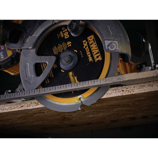 Close-up of a DEWALT DT1472 circular saw cutting through a wooden board, showing the blade in action.