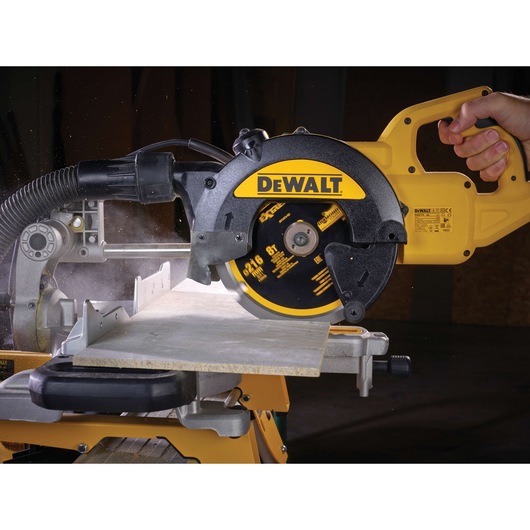 DEWALT circular saw cutting wood, close-up view with hand operating the tool in workshop setting.