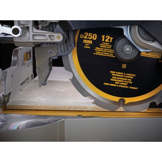 Close-up of a DEWALT DT1474 circular saw blade cutting through a laminate board on a power saw.
