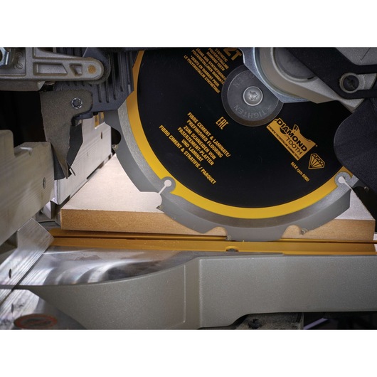 DEWALT circular saw cutting a wooden board, close-up of the blade and workpiece.