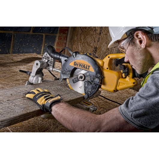 DEWALT circular saw cutting wood, operated by a person wearing gloves and a safety helmet.