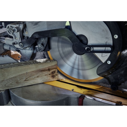 Close-up view of a DEWALT circular saw cutting through a wooden plank.