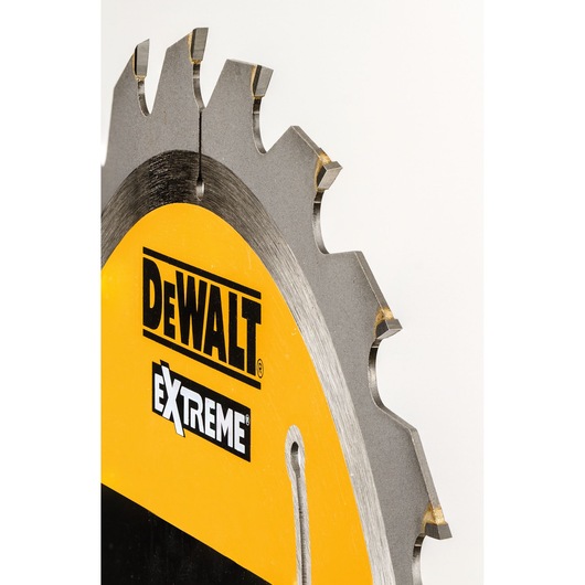 Close-up of a DEWALT Extreme circular saw blade with visible teeth and logo on yellow background.