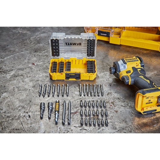 DEWALT drill, yellow bit case, and various drill bits arranged neatly on a workshop table.