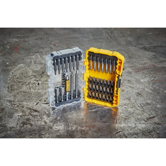 DEWALT DT70702 bit set in an open yellow storage case, displayed on a metal surface.