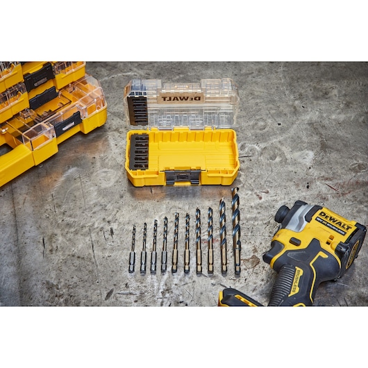 DEWALT drill bits set with yellow case and cordless drill laid out on a metal workbench.