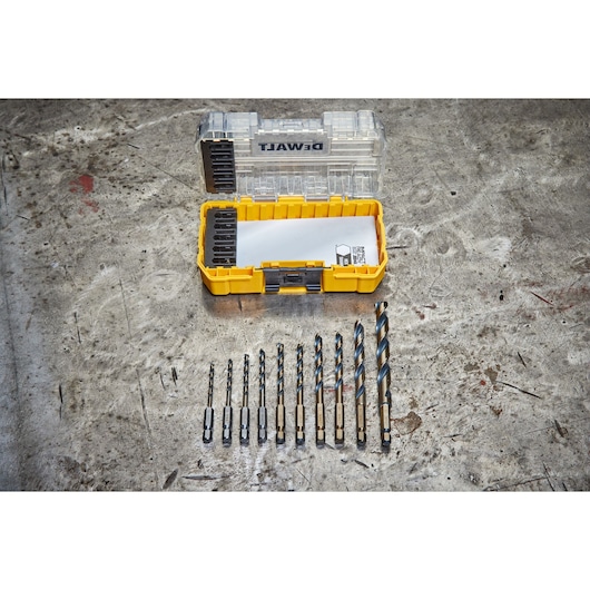 DEWALT drill bit set in an open yellow case on a worn metal surface, with various bits arranged in front.