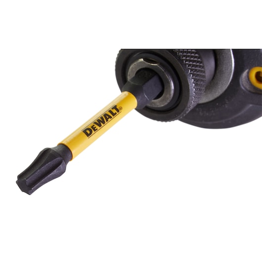 Close-up of a DEWALT screwdriver bit attached to a power tool, showing the yellow branded shaft.