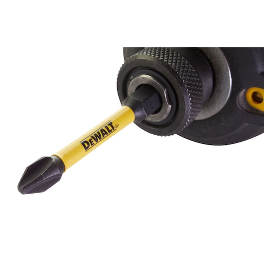 DEWALT screwdriver bit attached to a power drill, close-up view on the tool and yellow branding.