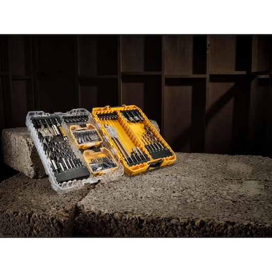 DEWALT DT70784 drill bit set in open cases, displayed on concrete blocks in a workshop setting.