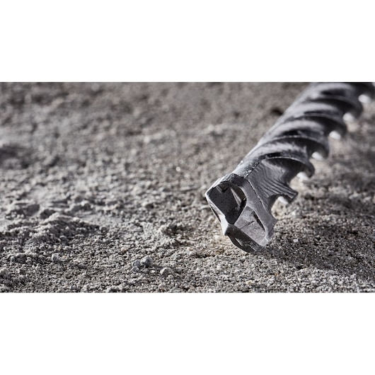 Close-up of a DEWALT DT8926 masonry drill bit resting on a rough concrete surface.