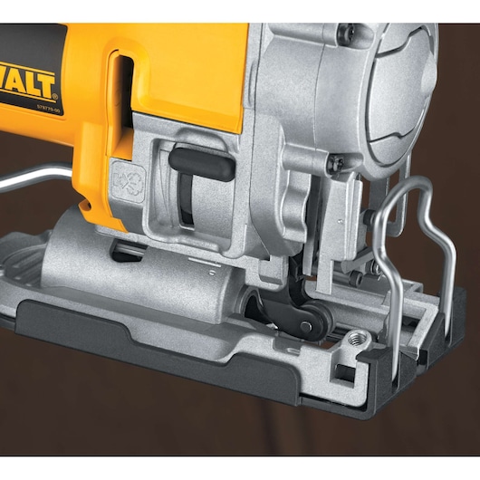 Close-up view of a DEWALT DW331K jigsaw, focusing on the metal base and mechanical components in a photography setting.