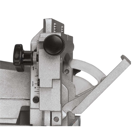 Close-up view of a DEWALT biscuit joiner adjustment mechanism with visible control knobs, depth gauge, and part of the cutting blade.