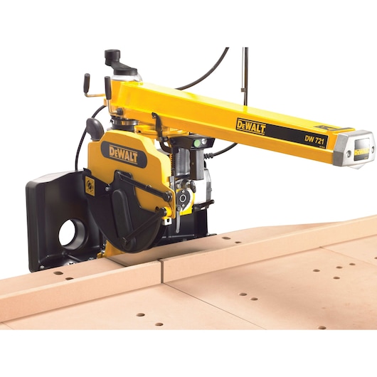 DEWALT DW721 radial arm saw cutting wood, yellow and black power tool on workbench.