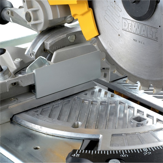 Close-up of DEWALT DW743N power saw showing blade, guard, and metal cutting surface.