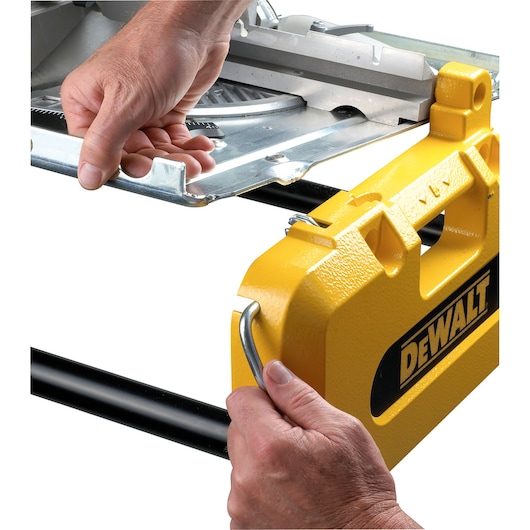 Hands adjusting yellow DEWALT machine parts, showing metal and branded components close-up.