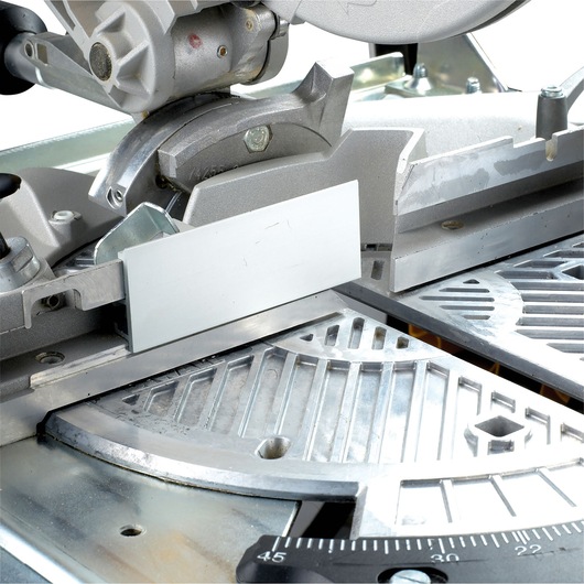 Close-up of a DEWALT DW743N mitre saw showing its metal cutting guide and angle measurement scale.