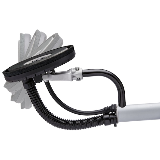 Close-up view of a DEWALT drywall sander head with flexible movement positions, showing the black sanding disc, brush edging, and connected hose attachment.