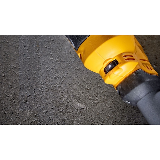 Close-up image of a yellow and black DEWALT power tool, showing a speed selector switch set to '3', on a textured grey surface.