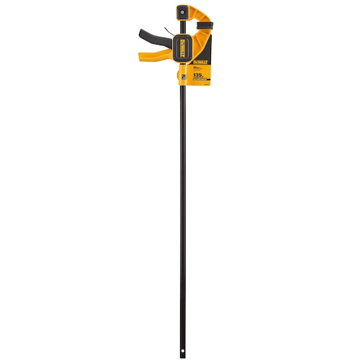 DEWALT trigger clamp with a long black bar and yellow ergonomic handle, used for holding materials securely during work.