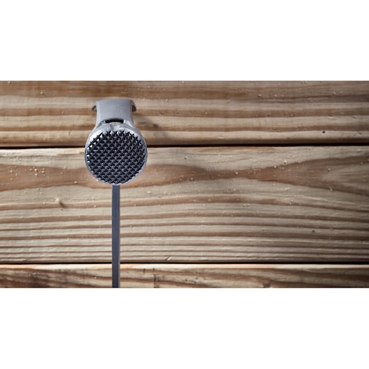 A DEWALT hammer with a textured striking face, positioned vertically against a wooden background.