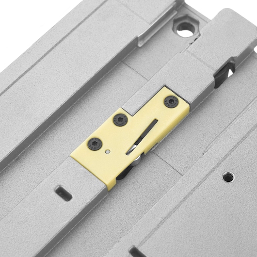 Close-up view of a metallic part with a yellow-colored section and black screws, likely a component of a DEWALT tool or equipment.