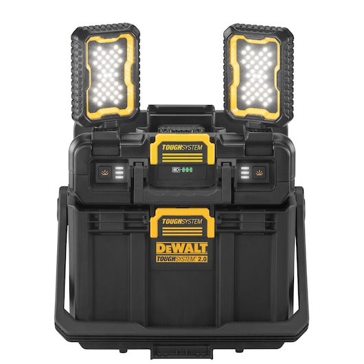 A DEWALT ToughSystem 2.0 portable storage box with two built-in LED work lights on top. The box is black and yellow, designed for durability and heavy-duty use, and features locking mechanisms and handles for easy transport.