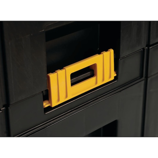 Close-up of a DEWALT black plastic toolbox showing a yellow latch detail.