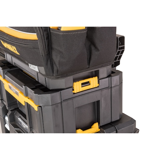 Stacked DEWALT toolboxes with yellow latches and a black fabric tool bag on top.