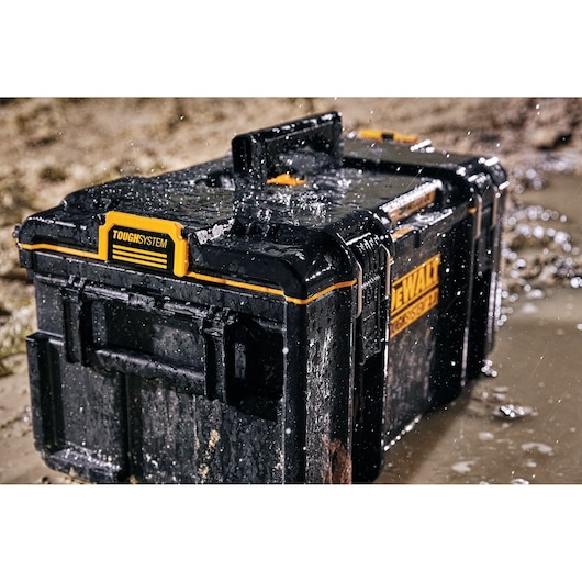 A DEWALT ToughSystem tool box, model DWST83294-1, shown wet and muddy in an outdoor environment, highlighting its durability