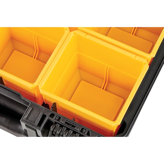 Close-up of yellow plastic organizer bins inside a black DEWALT storage case.