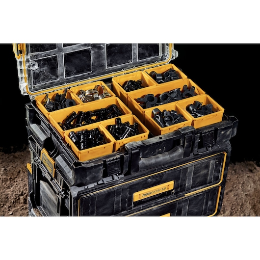 DEWALT ToughSystem toolbox open with yellow compartments holding assorted small hardware items.