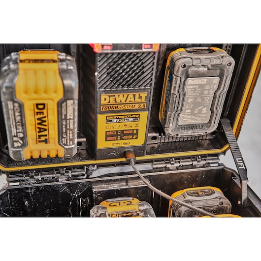 DEWALT ToughSystem 2.0 battery charger with connected batteries inside a black storage case.