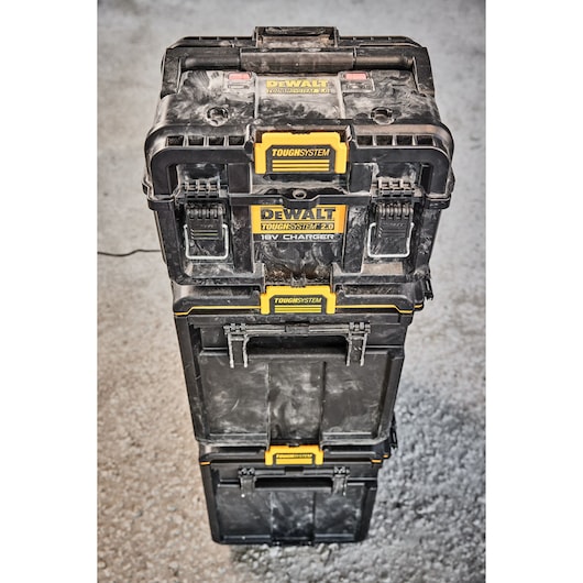Stacked DEWALT Toughsystem 2.0 toolboxes with charger unit on a concrete floor, shown from above.