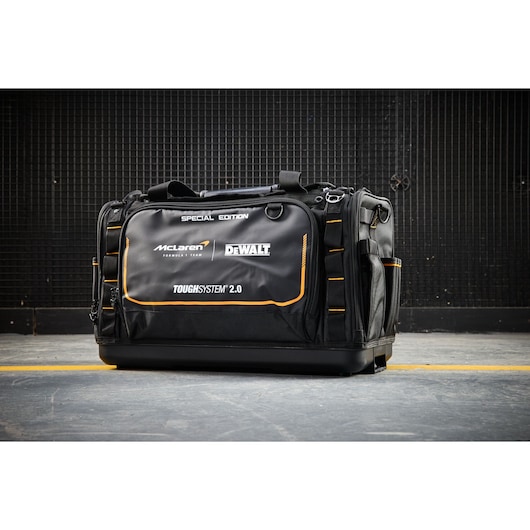 Special edition DEWALT ToughSystem 2.0 tool bag, black with orange accents, shown on a concrete floor.