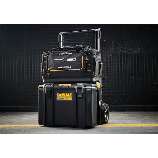 DEWALT Toughsystem 2.0 tool bag and wheeled toolbox stacked on floor, black with yellow accents.