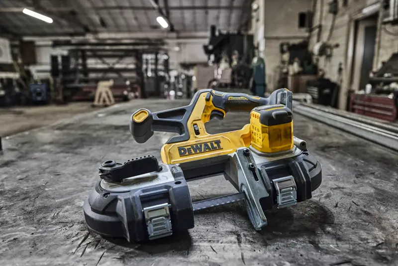 DEWALT cordless band saw placed on a metal workbench in a workshop setting.